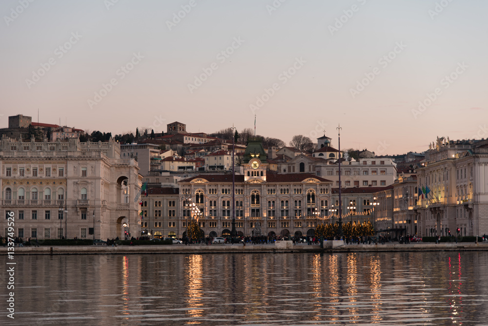 Ultimi raggi di sole sul mare e sui palazzi di Trieste
