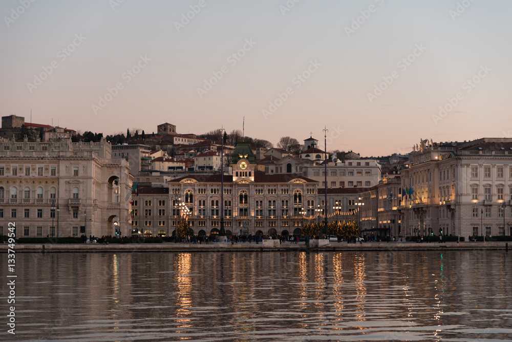 Ultimi raggi di sole sul mare e sui palazzi di Trieste