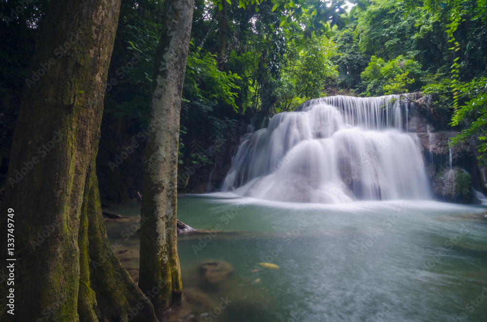 Fototapeta premium Erawan Waterfall, beautiful waterfall with sunlight rays in deep forest, Erawan National Park in Kanchanaburi, Thailand
