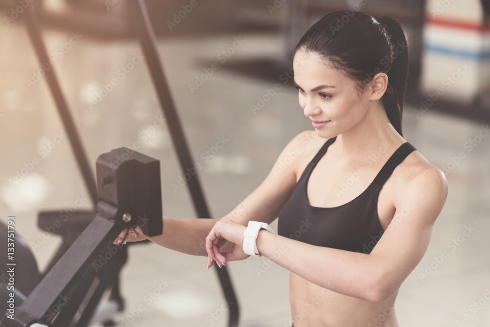 Active woman using smart watch in a gym Active woman using smart watch in a gym