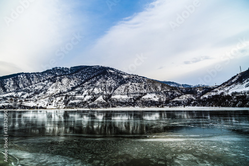 Winter landscape with mountains reflected in the river