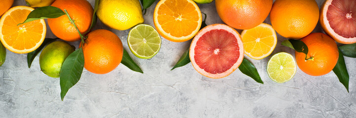 Citrus fruit on grey concrete table. Food background. Healthy eating. Long banner format good for web.