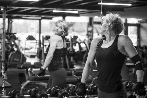 femme e regardant dans un miroir dans une salle de sport photo