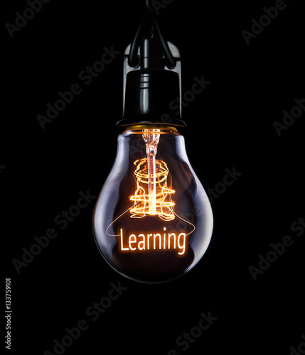 Hanging lightbulb with glowing Learning concept.