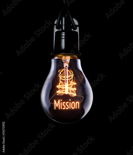 Hanging lightbulb with glowing Mission concept. photo