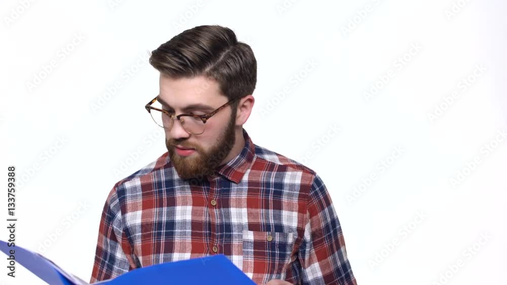 Mad unsatisfied casual businessman in eyeglasses holding folder with report Mad unsatisfied casual businessman in eyeglasses holding folder with report