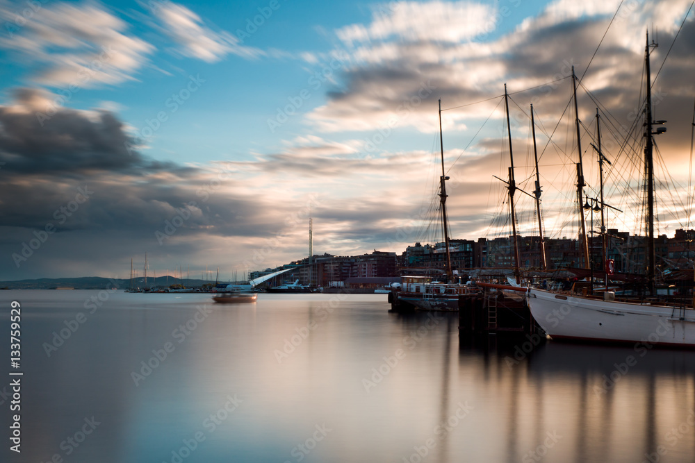 Oslo harbour at sunset. From Rådhusbrygga til Tjuvholmen. Long exposure