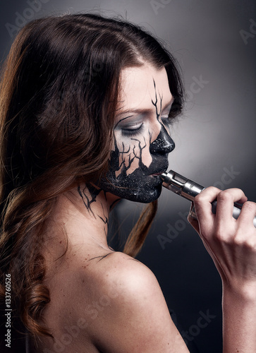 girl with make up and electronic cigarette making clouds photo