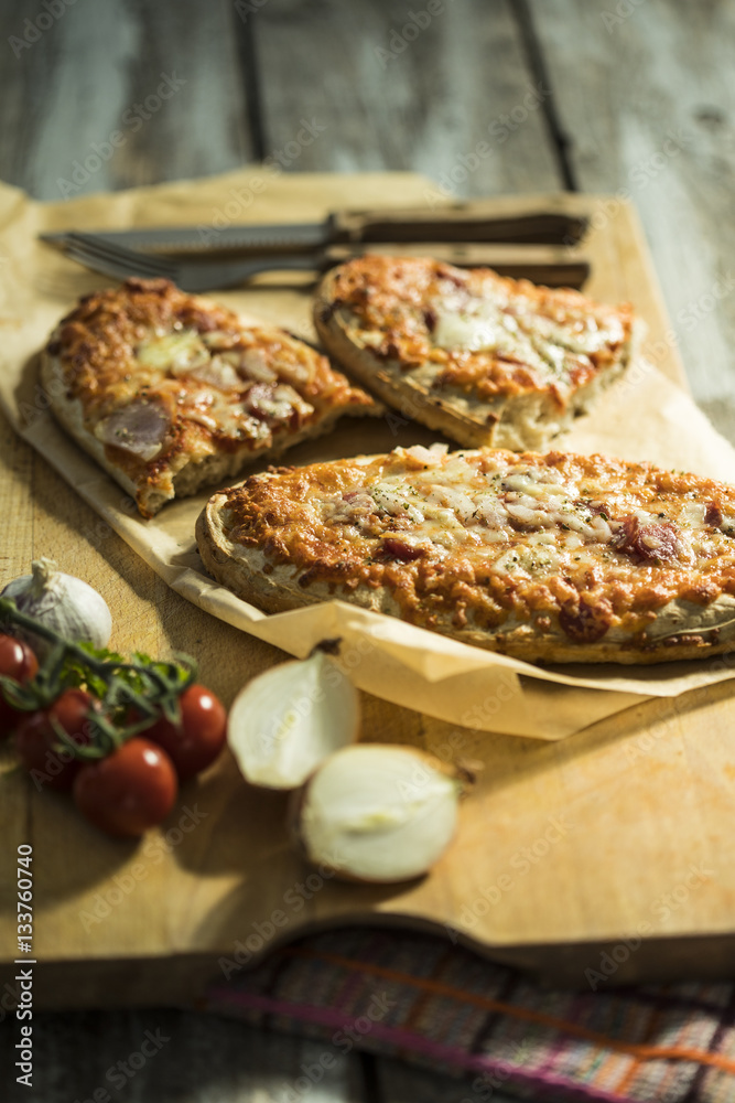 rustikales Pizzabrot mit Salami, Käse, Zwiebeln und Tomate
