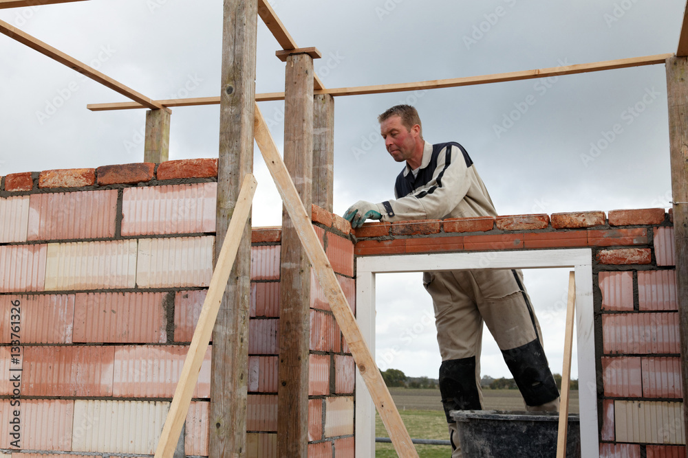mason bricklayer is building a brick wall outdoors mason bricklayer is building a brick wall outdoors
