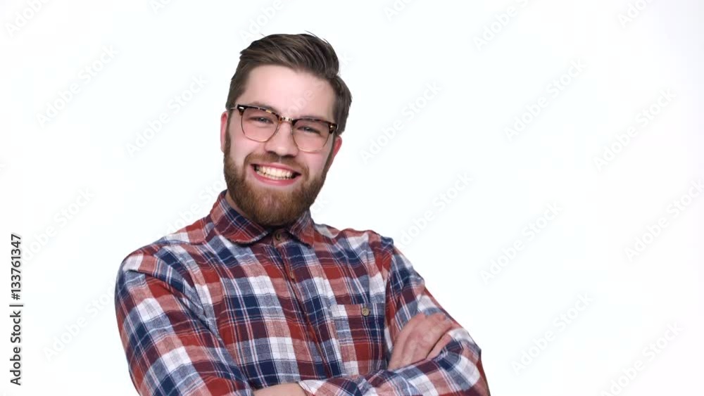 Happy young man in eyeglasses pointing at camera and smiling while standing against white background Happy young man in eyeglasses pointing at camera and smiling while standing against white background