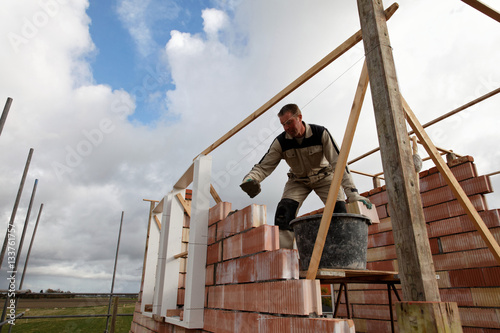 bricklayer mason is building a new house on country