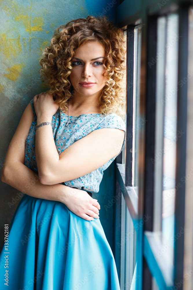 portrait of beautiful young woman in a casual top and skirt with perfect makeup and hair style