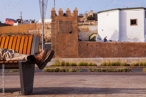 The man lies on a bench photo