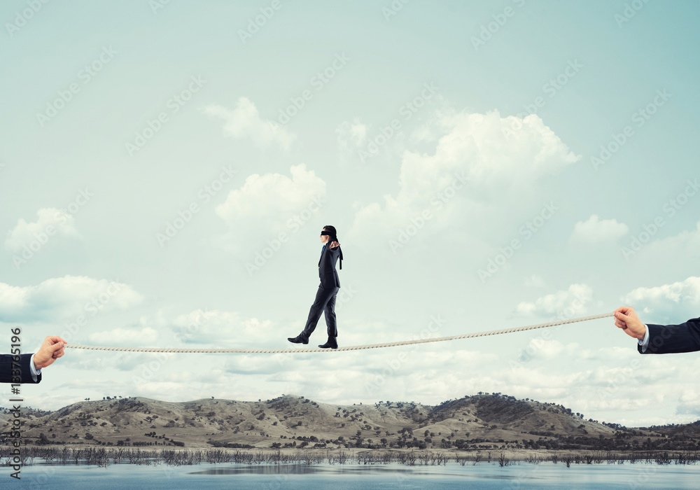 Obraz premium Business concept of risk support and assistance with man balancing on rope