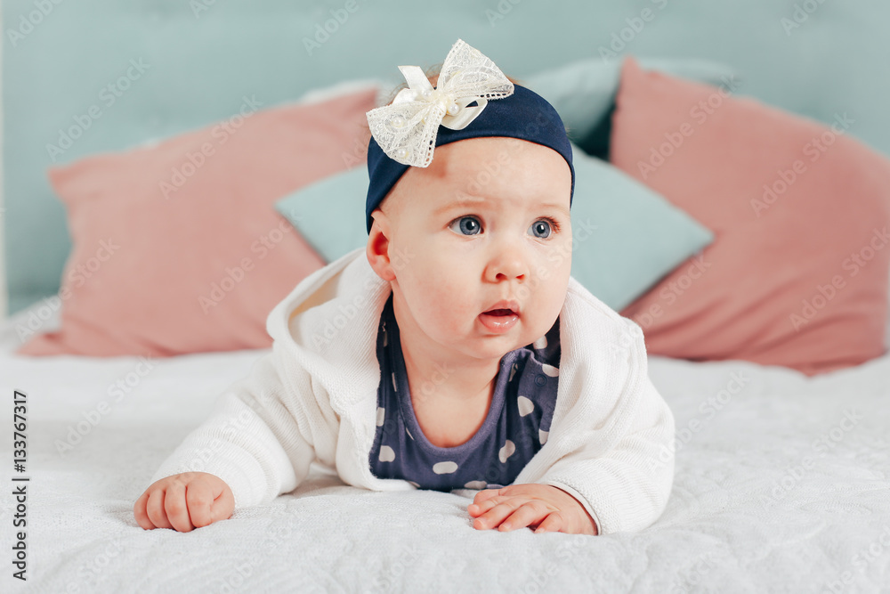 Adorable two month old baby girl lying on the pillow and looking into the camera Adorable two month old baby girl lying on the pillow and looking into the camera
