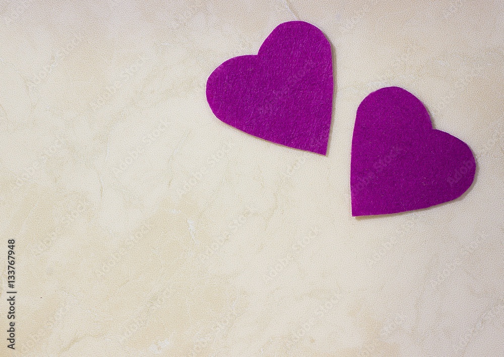 Obraz premium A two decorative purple hearts on light background