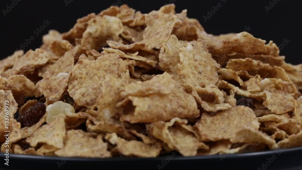 Granola cereal, nuts and raisins rotating . Crunchy tasty muesli food background close-up. Cereals and dried food mixed for breakfast Granola cereal, nuts and raisins rotating . Crunchy tasty muesli food background close-up. Cereals and dried food mixed for breakfast