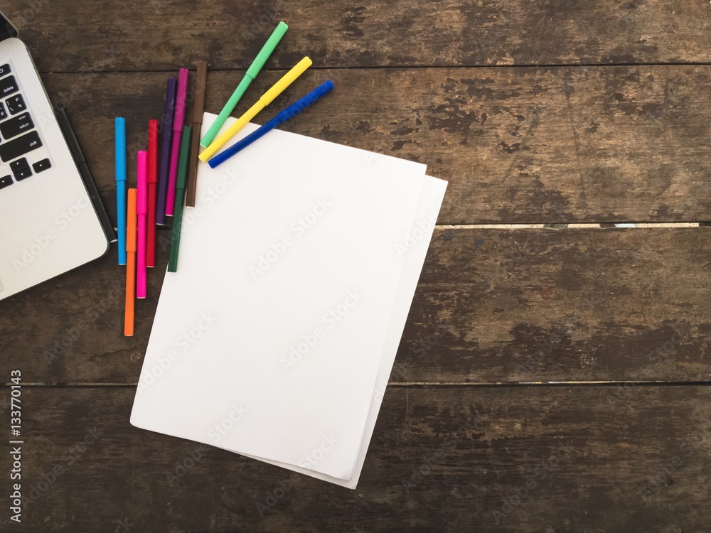 Laptop and marker on the wooden table with space on right side. Laptop and marker on the wooden table with space on right side.