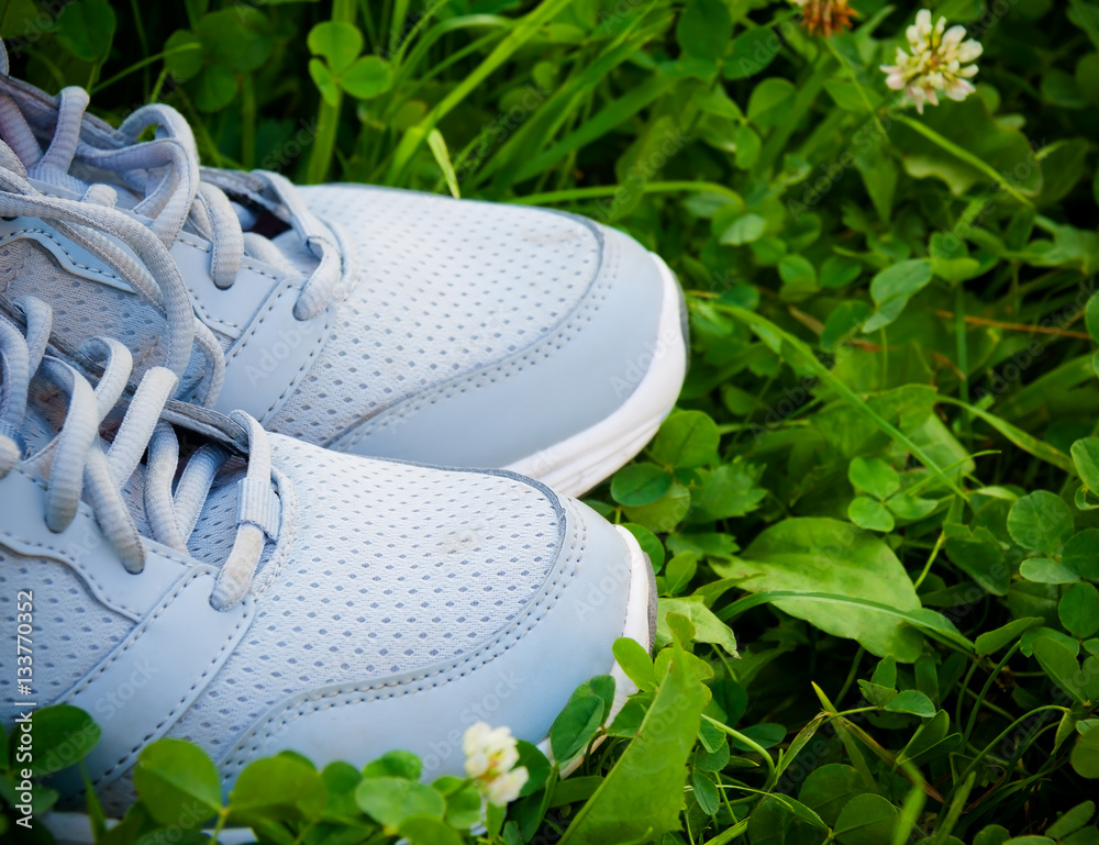 Sports shoes sneakers on fresh green grass. Selective focus Stock-Foto