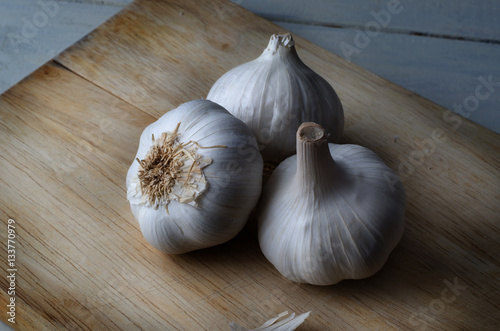 Three Whole Garlic Bulbs on Wooden Chopping Board