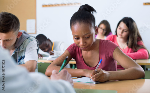 Enthusiastic girls and boys taking the notes while