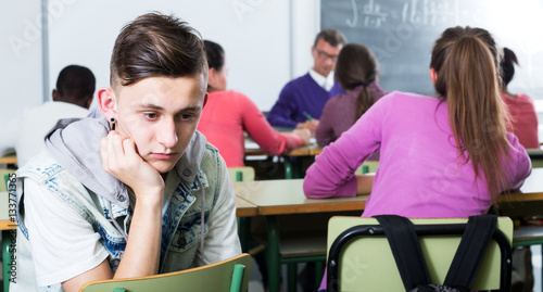 Alone outcasted student being mobbed by other students photo