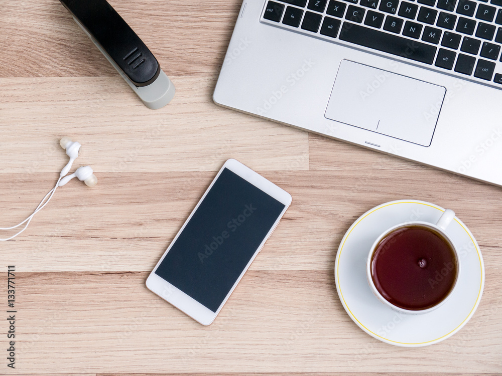 Wooden table with smartphone and Cup of tea, Desk. The view from the top Wooden table with smartphone and Cup of tea, Desk. The view from the top