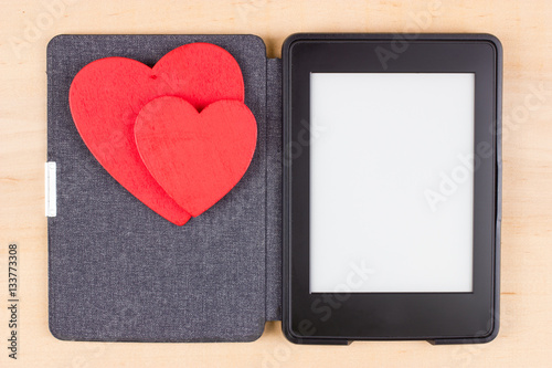 Card for Valentine's Day with two red hearts on e-book reader with copy space on screen