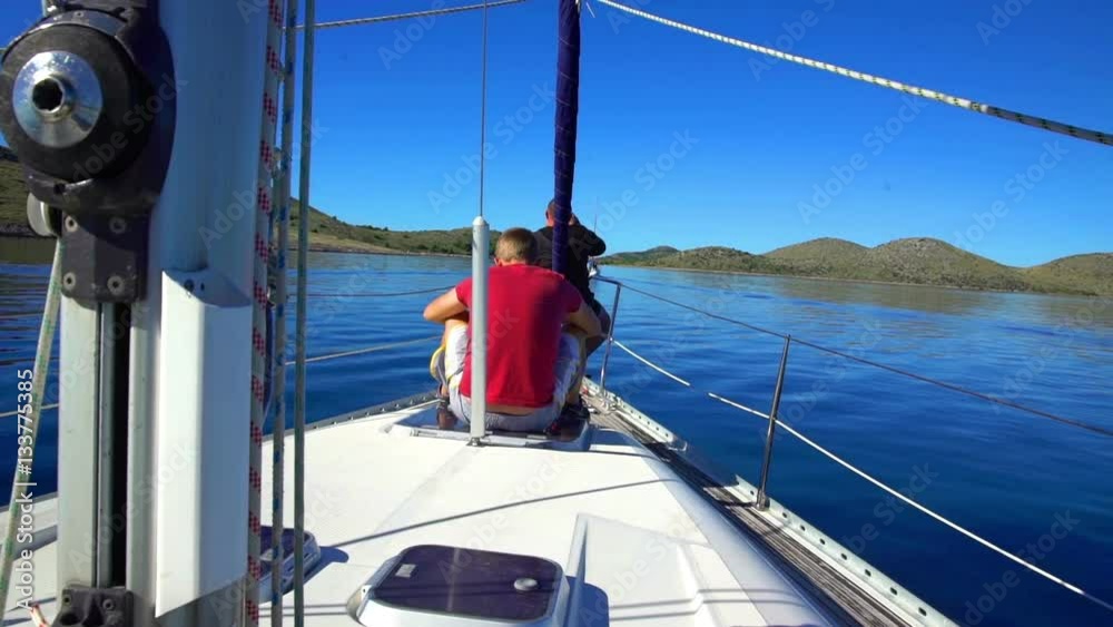 A guy is sitting peacefully on the sailing boat's stern and he doesn't move. He is observing the beautiful nature. The day is really amazing and sunny.
A guy is sitting peacefully on the sailing boat's stern and he doesn't move. He is observing the beautiful nature. The day is really amazing and sunny.