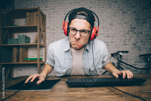 Young man playing game at home and streaming playthrough or walkthrough video photo