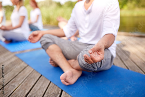 close up of people making yoga exercises outdoors