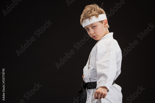 Obraz na plátně black belt karate blond kid isolated on black