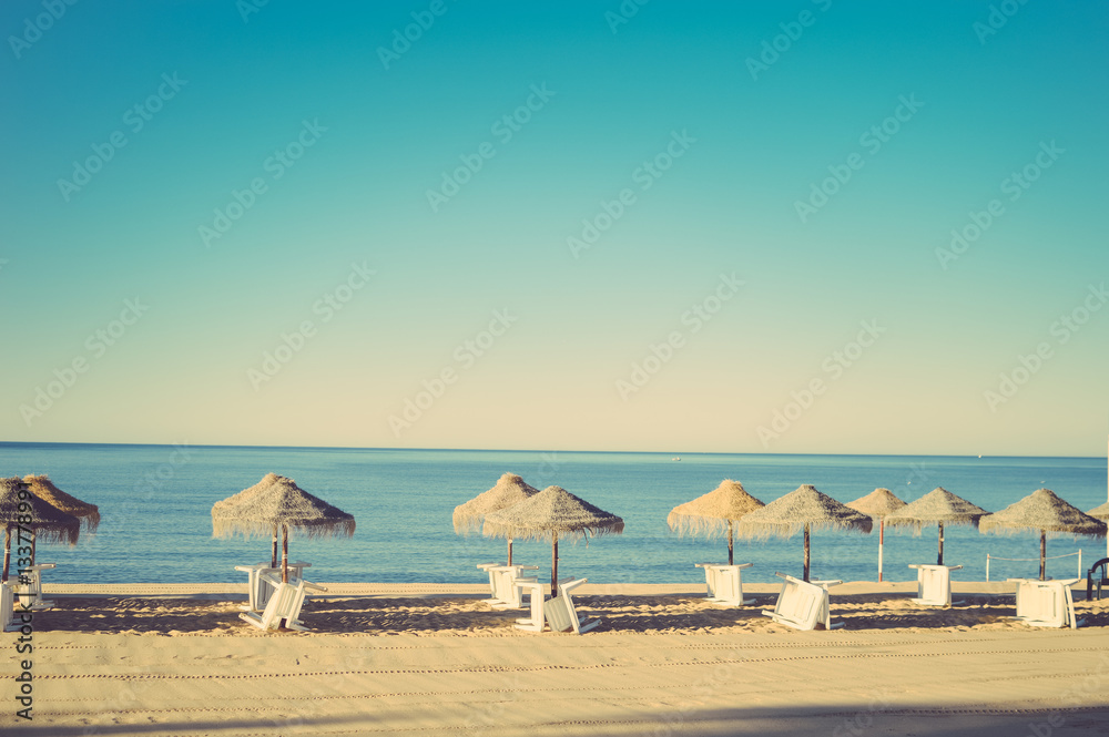 Holiday and vocation image with beach lounge and parasol on ocean sea outdoors sunny background