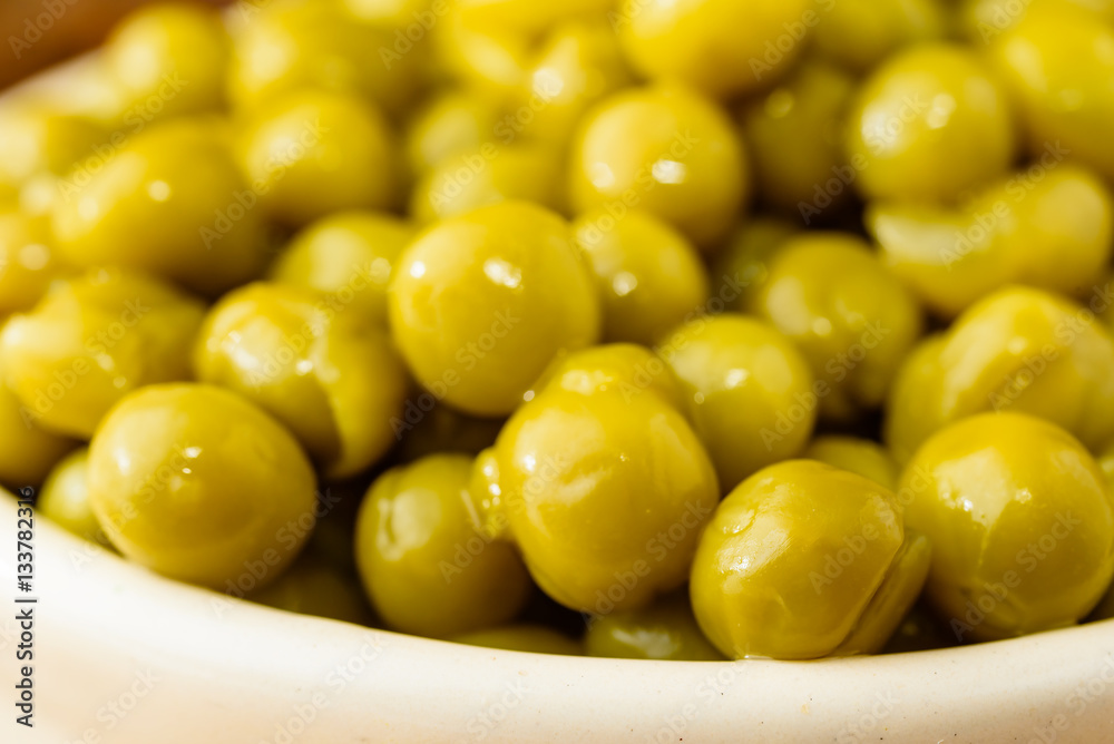Steamed and chilled green peas ready to eat. Sweet and fresh to the taste. Here close up in a beige enameled cast iron pot. Steamed and chilled green peas ready to eat. Sweet and fresh to the taste. Here close up in a beige enameled cast iron pot.