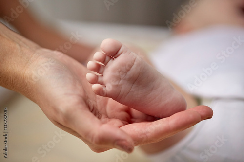 close up of newborn baby foot in mother hand