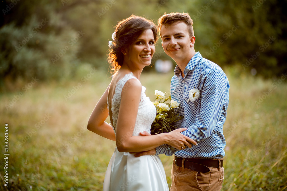 Fototapeta premium Couple on the nature, the bride and groom hugging at the wedding.