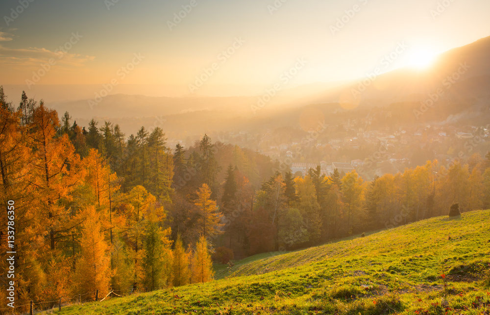 autumn landscape with town at sunset