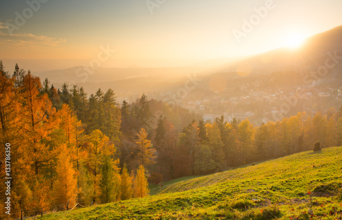 autumn landscape with town at sunset