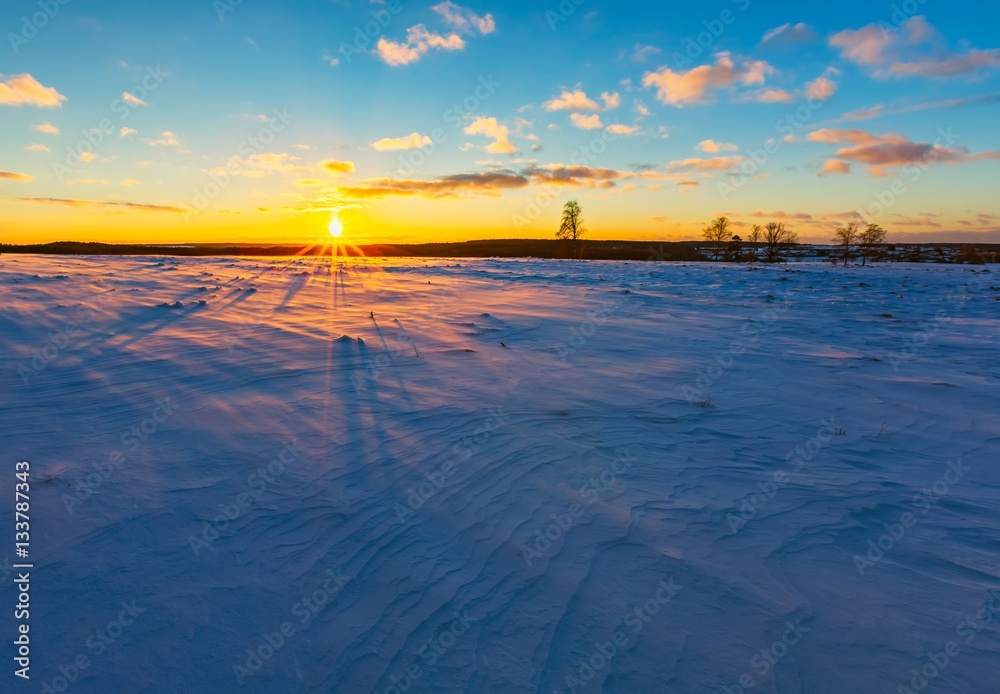 Winter fields sunset with snow moving by wind
