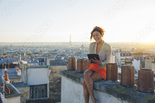 Sticker Young woman using a tablet pc on the roofs of Paris