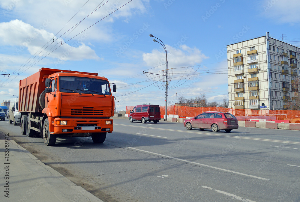 Грузовик-самосвал едет по автомобильному шоссе в Москве Грузовик-самосвал едет по автомобильному шоссе в Москве