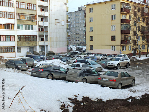 Жилые дома и припаркованные во дворе автомобили пасмурным зимним днем photo