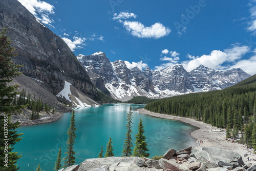 Fototapeta Naklejka Na Ścianę i Meble -  Moraine lake in Banff National Park, Canadian Rockies, Canada. Sunny summer day with amazing blue sky. Majestic mountains in the background. Clear turquoise blue water.