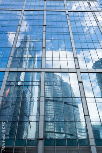 skyscrapers of steel and glass reflected in buildings facade