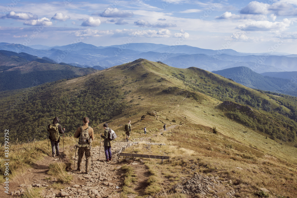 Obraz premium Grupa paramilitarnych ludzi idzie po szlaku w górach Bieszczady