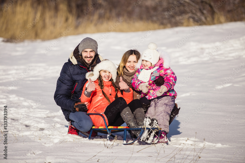 Happy family with sled winter sunny day