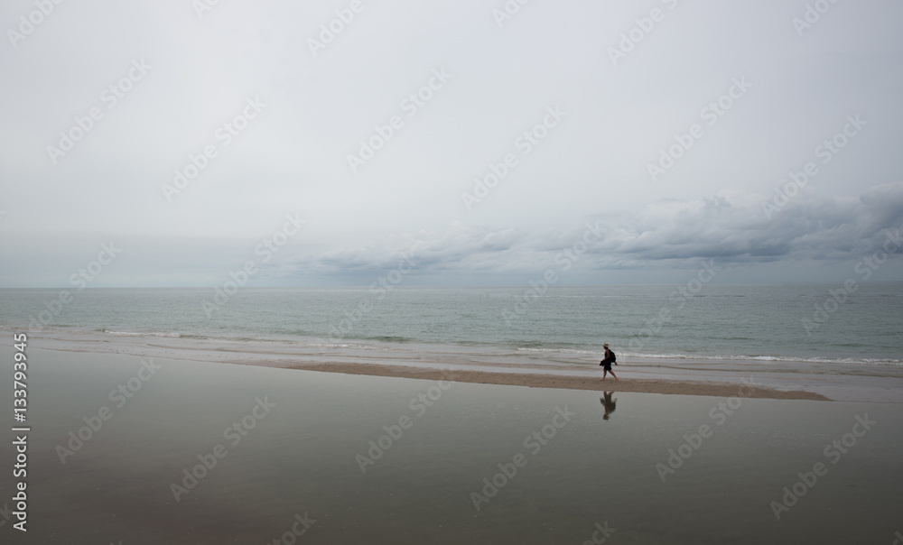 Lonely man walking on the beach