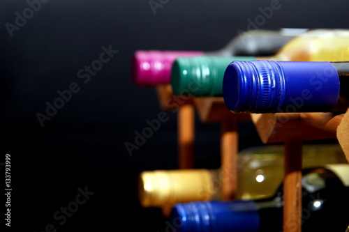 Various red and white wine bottles in a wooden wine rack with sp