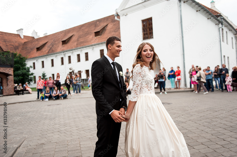 gorgeous happy wedding couple walking and kissing in the old city of Minsk, Belarus gorgeous happy wedding couple walking and kissing in the old city of Minsk, Belarus